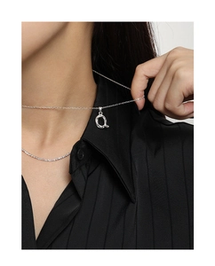Irregular silver pendant necklace shown on model with minimalist modern aesthetic