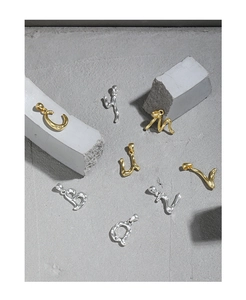Detailed view of gold and silver letter pendants with organic molten lava textures