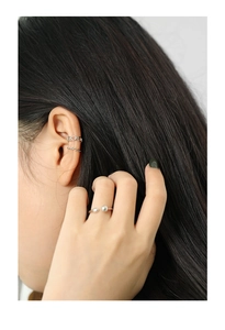 Details von silbernen Ohrmanschetten und offenem Ring mit Kugeln am Modell