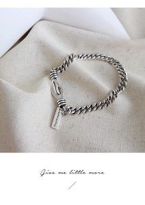 Macro shot of S925 sterling silver chain bracelet with rectangular tag and U-hook clasp