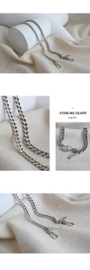 Macro detail of S925 sterling silver chain with S-hook clasp and engraved logo tag