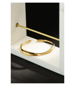 Detailed macro view of the minimalist gold irregular wave bangle with matte finish
