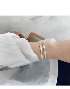 Close-up of gold and silver S925 sterling silver bracelets with irregular hammered texture