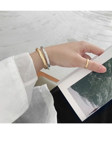 Detail of gold and silver hammered textured open cuff bracelets and matching ring
