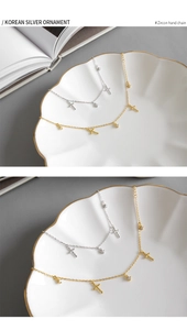 Dettaglio dei bracciali in argento S925 con ciondoli a croce e zirconi in oro e argento