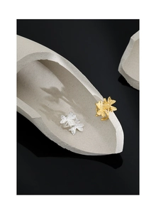 Macro detail of gold and silver flower rings with matte textured clover petal design