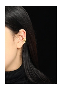 Detail of clover leaf shaped gold ear cuff featuring a delicate brushed texture on S925 silver