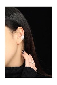 Macro detail of silver double butterfly ear cuff and solitaire ring set on a model