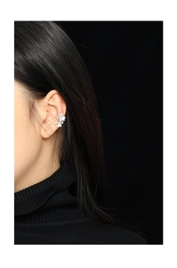 Detail of silver clover ear cuff with zircon crystals, shown on model's ear profile