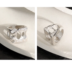 Detail of S925 sterling silver hollow ring with engraved text on an artistic open band
