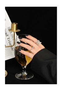 Detailed view of silver minimalist hollowed-out wide ring set on model with black nails