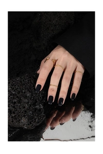Minimalistisches goldener Ring-Set auf schwarzem Lavastein und Wasserfläche zur Präsentation