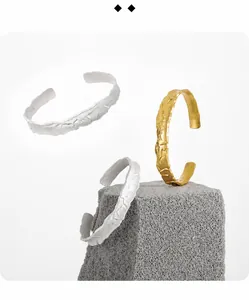 Dettaglio di bracciali in argento sterling S925 con texture irregolare in oro e argento