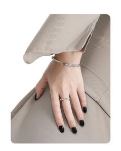 Detailed view of silver cuff bracelet and ring set with square pavé zircon on model