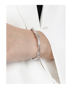 Macro detail of silver S925 sterling silver twisted vine bracelet on woman's wrist