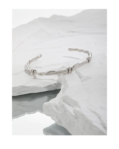 Macro shot of S925 sterling silver stamp on minimalist twisted vine open cuff bracelet