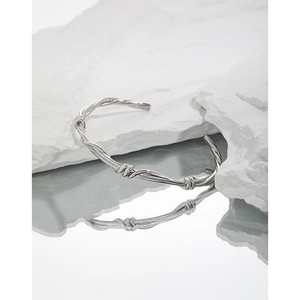 Minimalist S925 sterling silver open bangle with vine wrap design on stone background