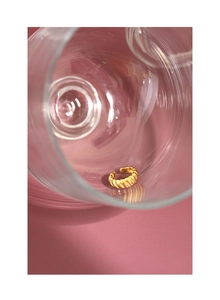 Makro-Detail eines goldplattierten gedrehten Rings mit Wellenstruktur im Glas