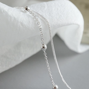 Bracelet de cheville double couche en argent sterling S925 sur tissu blanc doux
