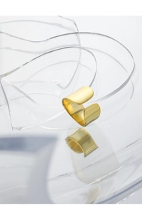 Detail view of a matte gold minimalist open ring featuring an irregular textured surface