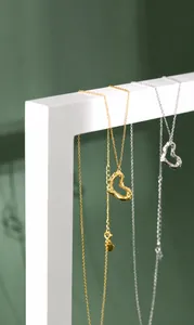 Detailansicht der unregelmäßigen Herzanhänger mit Lava-Textur in Gold und Silber am Ständer