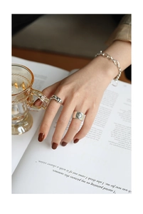 Nahaufnahme von S925 Sterlingsilber Knotenring und Vintage-Münzring an der Hand