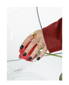 Detailed view of three minimalist gold rings including a checkered pattern on hand