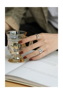 Makro-Detail von Retro S925 Sterling Silber Knotenring und Relief-Münzring am Finger