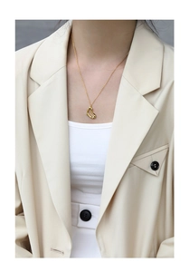 Nahaufnahme der goldenen Herz-Halskette mit unregelmäßiger Textur im Business-Look