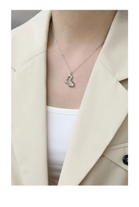 Detail eines unregelmäßig texturierten Herzanhängers aus S925 Silber am Hals