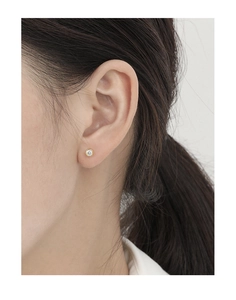Close-up of minimalist gold S925 silver stud earring with round zircon on ear