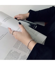 Nahaufnahme von minimalistischem Silberkettenarmband und strukturiertem Ring
