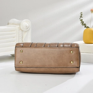 Dettaglio della base della borsa in pelle marrone con quattro piedini in metallo dorato