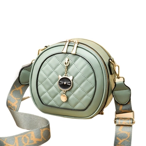 Sac bandoulière rond vert menthe matelassé avec pendentif chat et sangle large