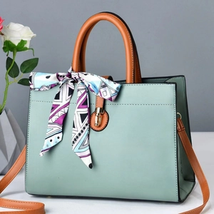 Elegant mint green crossbody bag with leather texture and silk scarf decoration on handle