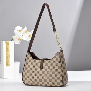 Detail of checkered underarm bag with gold chain strap and brown leather trim