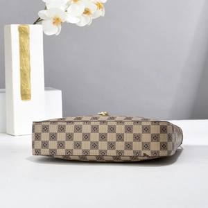 Detail view of checkerboard pattern handbag with floral prints and metal bottom clasp