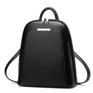 Detailed view of the black leather backpack's silver metal logo and dual zipper closures