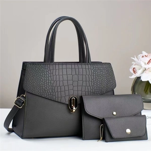 Detailed set of grey handbag with crocodile pattern flap and golden twist lock