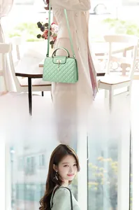 Detail of light green quilted handbag with gold handle and deer charm on long strap