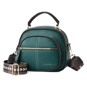 Green leather crossbody bag with decorative white stitching and jacquard strap