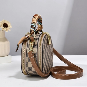 Détail d'un sac rond à damier avec poignée en foulard de soie et fermoirs dorés