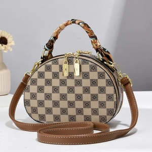 Détail du sac à carreaux avec imprimé floral et foulard en soie autour de l'anse