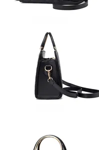 Detail of black quilted handbag featuring golden round handles and trapezoid structure