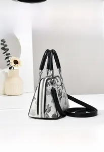 Detailansicht der weißen Lederhandtasche mit Blumenmuster und silbernem Reißverschluss