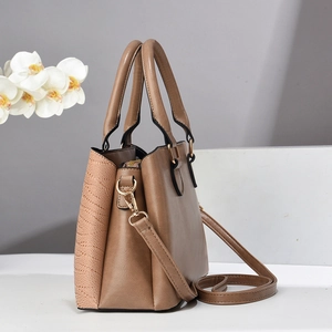 Detail of brown stone pattern handbag with metallic gold hardware and adjustable strap
