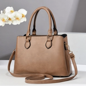 Detail of khaki tote bag showing smooth leather texture and crocodile pattern side panels