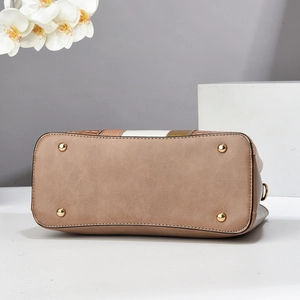 Detail view of khaki leather bottom with gold metal feet on a patchwork handbag
