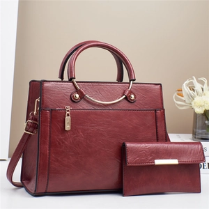 Close-up of wine red faux leather handbag set featuring lychee texture and gold hardware