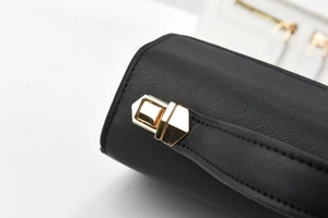 Détail d'un sac à main noir en cuir Saffiano avec un fermoir doré métallique chic